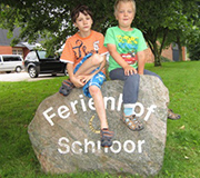 Kinder auf dem Stein vom Ferienhof Schnoor.